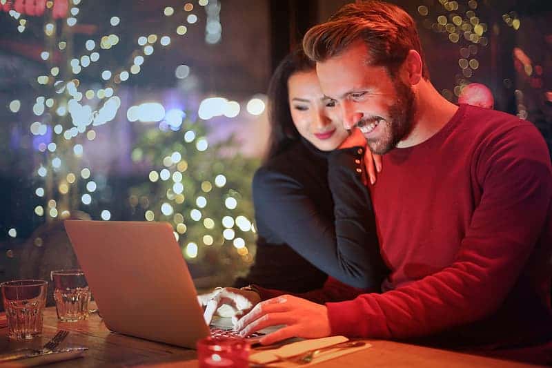 young-couple-surfing-on-internet-with-laptop-during-romantic-dinner-in-a-restaurant