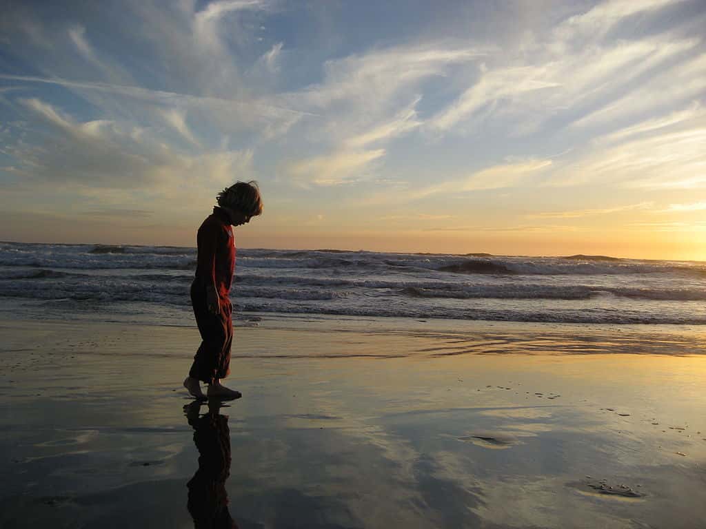 Kid_on_Beach_Looking_at_the_Sky_in_the_Sand