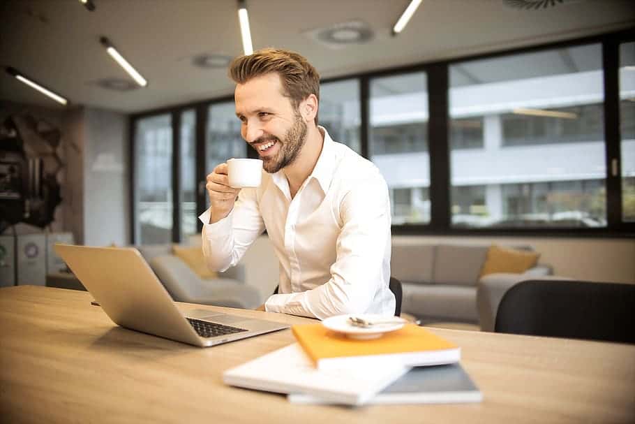 business-man-smiling-coffee-cup-laptop