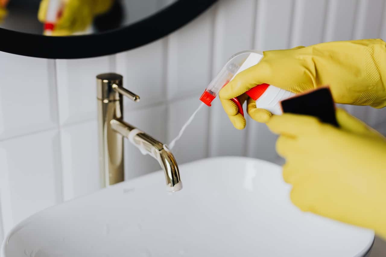 faceless-cleaner-in-gloves-tiding-up-bathroom-4239130