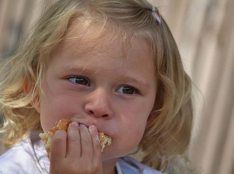 girl-in-white-shirt-eating-brown-bread
