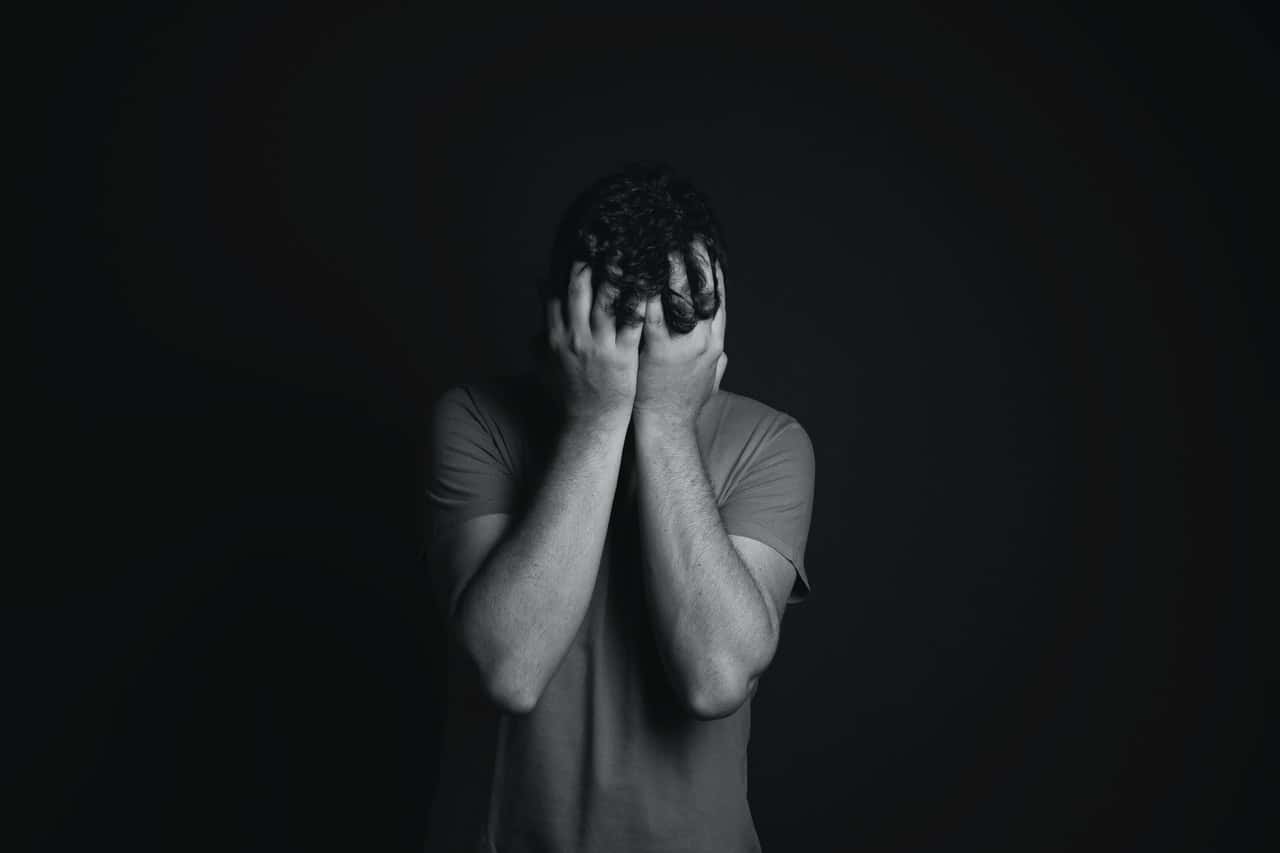 gray-scale-photo-of-man-covering-face-with-his-hands-3601097