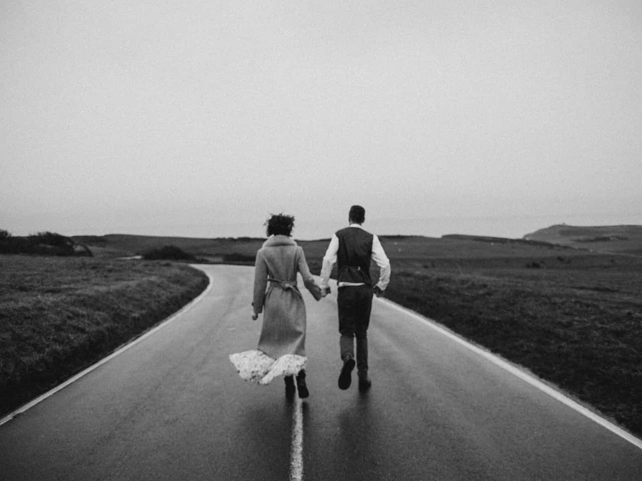 grayscale-photo-of-couple-walking-on-road-3617517