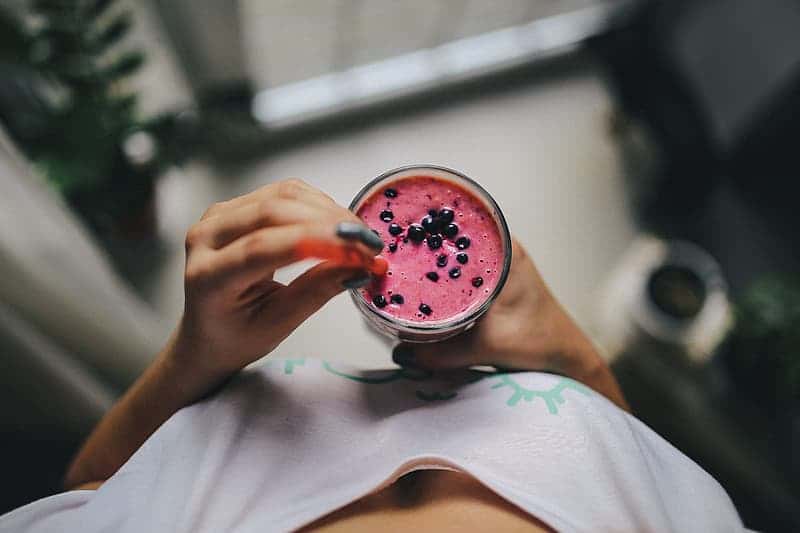 person-holding-clear-drinking-glass-with-pink-liquid