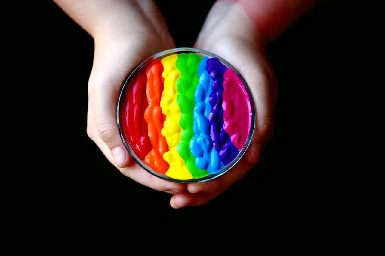 person-holding-multicolored-container-1209870