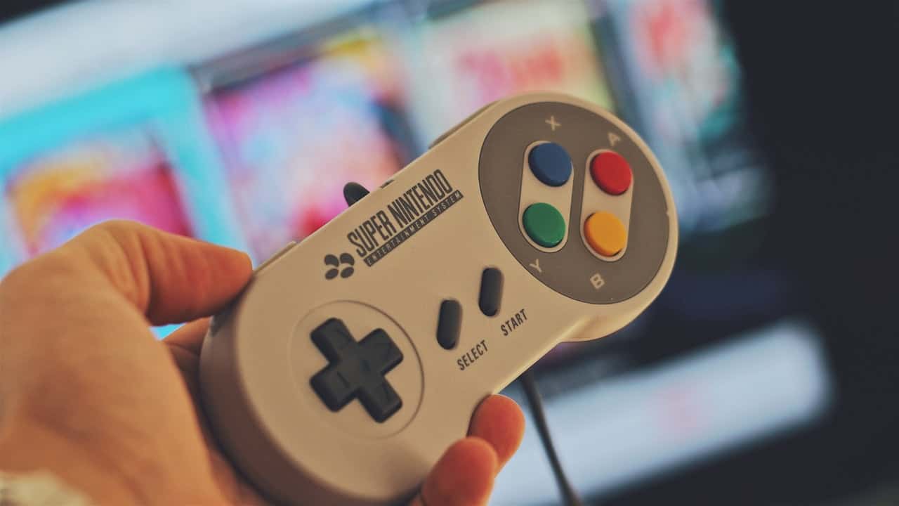 person-holding-white-snes-controller-776092