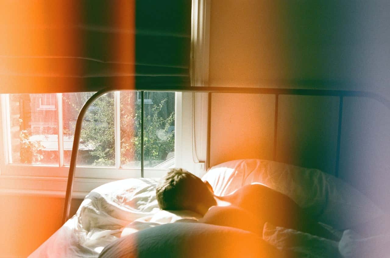 person-lying-in-bed-beside-window-1572728