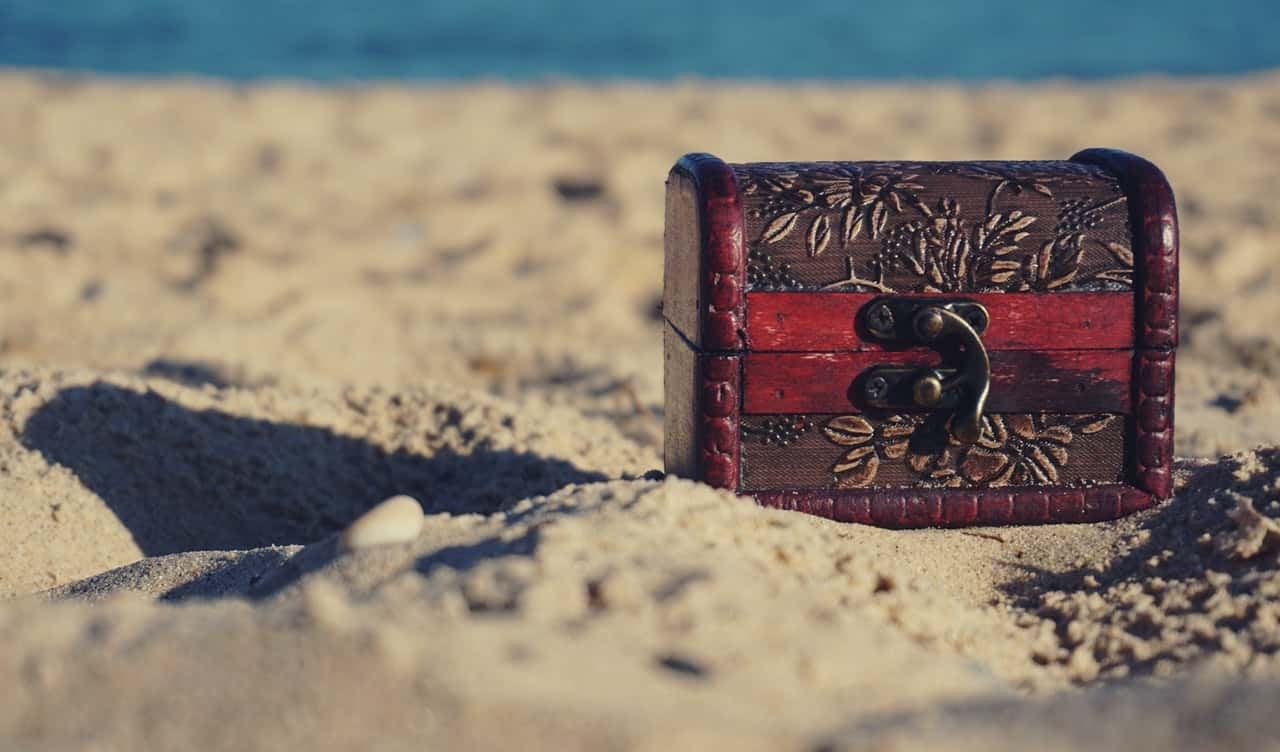 red-and-black-wooden-chest-on-white-sand-1252907