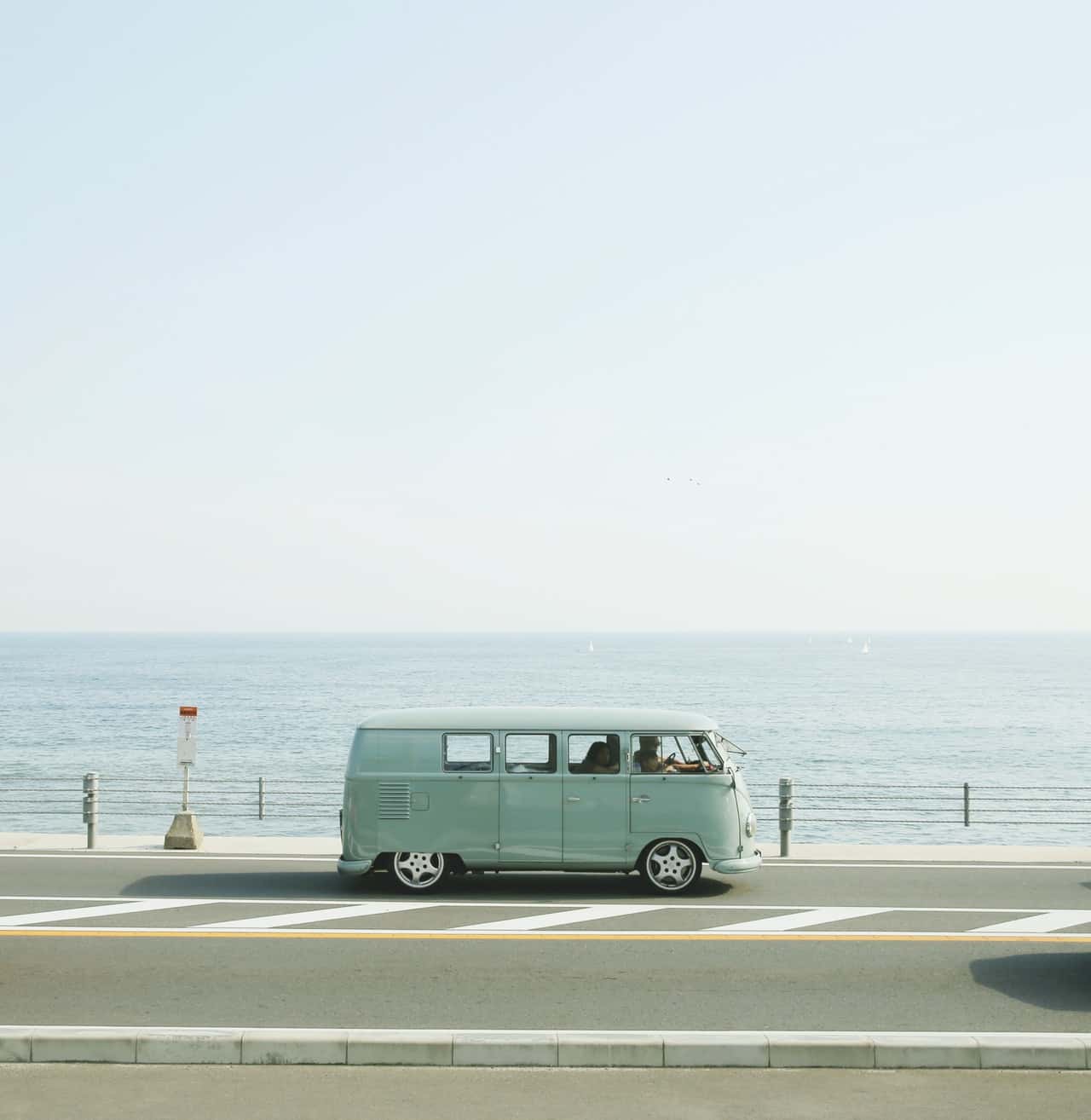 van-parked-beside-the-road-near-handrail-and-ocean-2303781