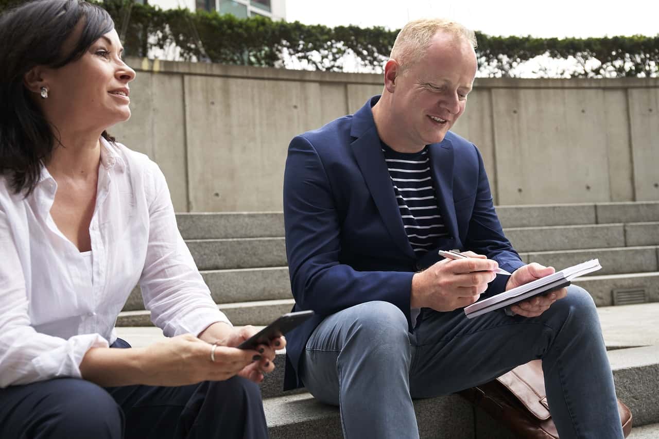 woman-and-man-having-a-discussion-while-sitting-on-steps-2977567