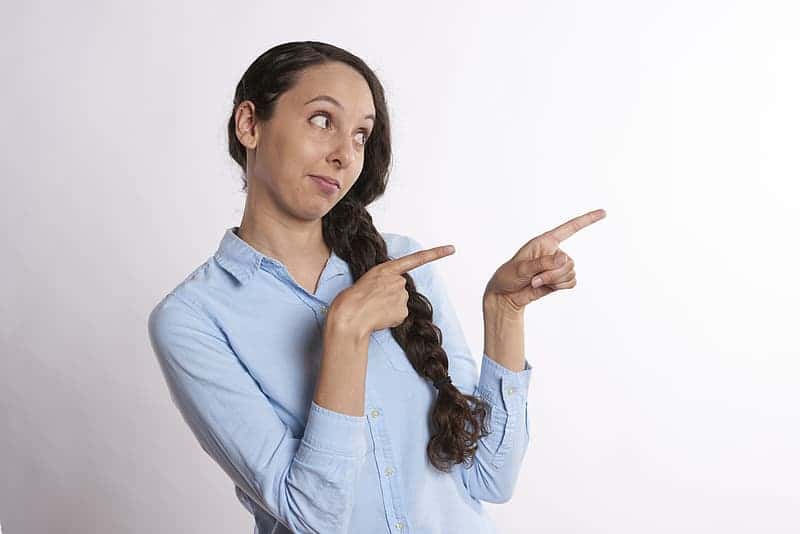 woman-pointing-her-two-index-fingers-on-right-side