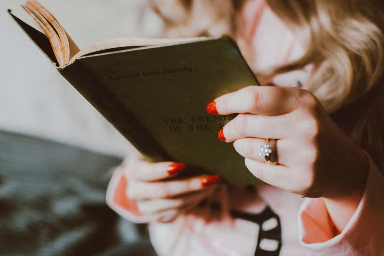 woman-reading-and-holding-book-1925942