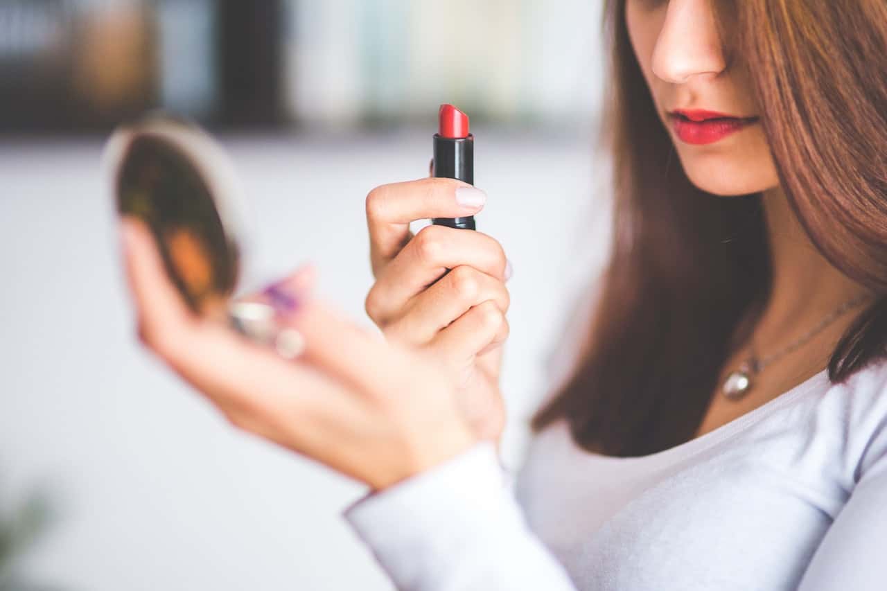 woman-with-brown-hair-doing-lipstick-and-holding-little-6393
