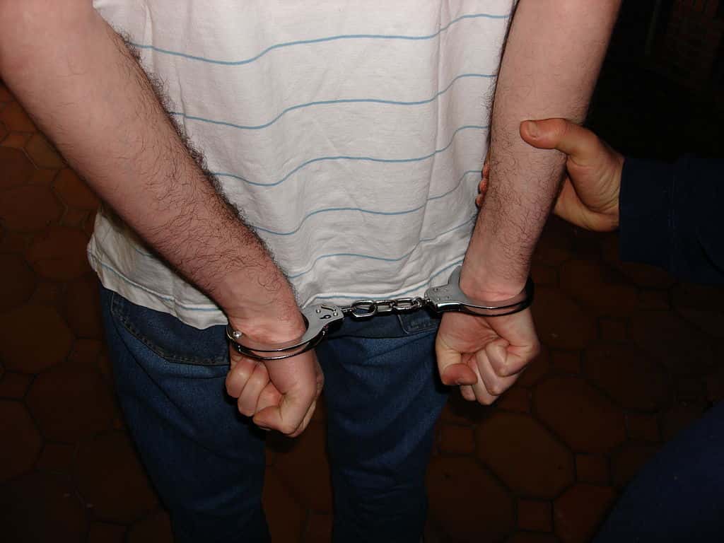 1024px-Handcuffed_man