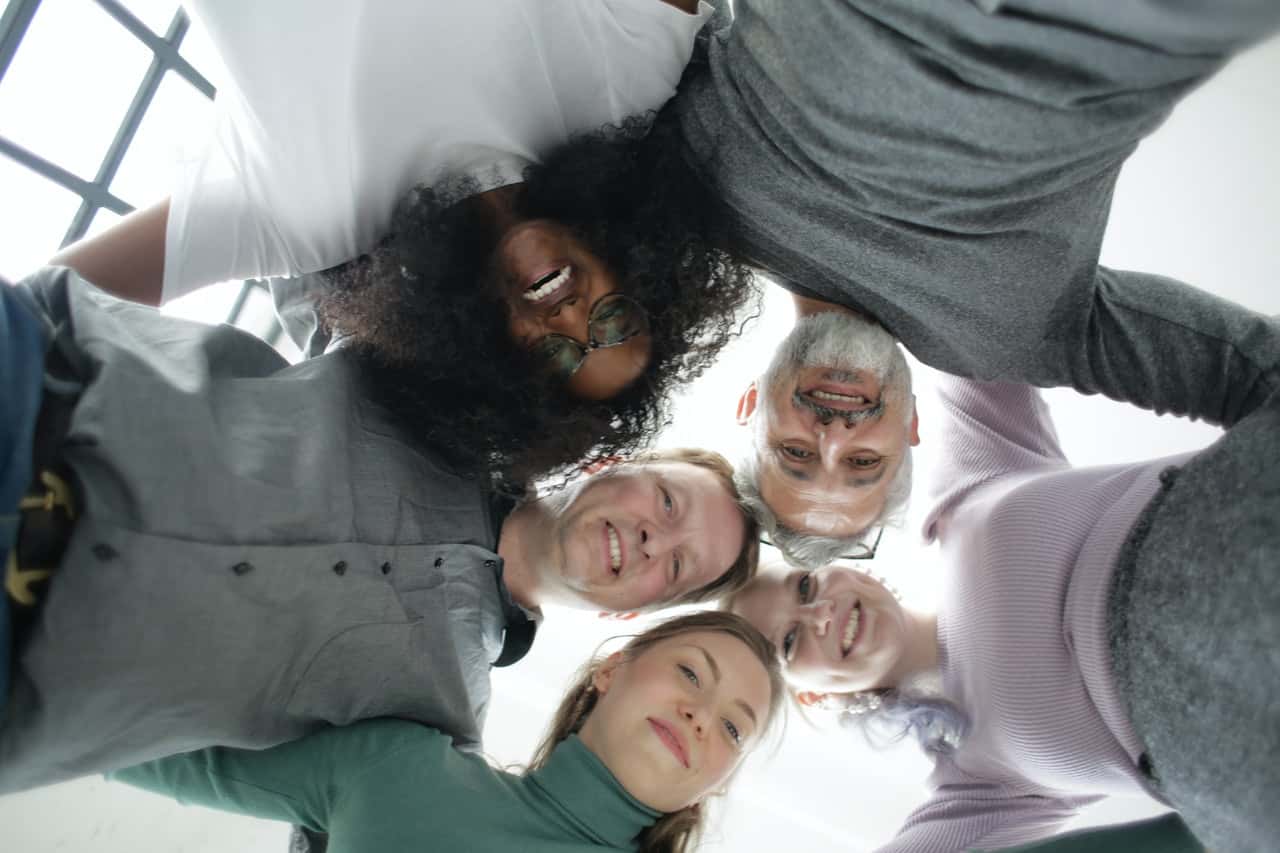 from-below-of-cheerful-multiethnic-coworkers-embracing-each-3931556