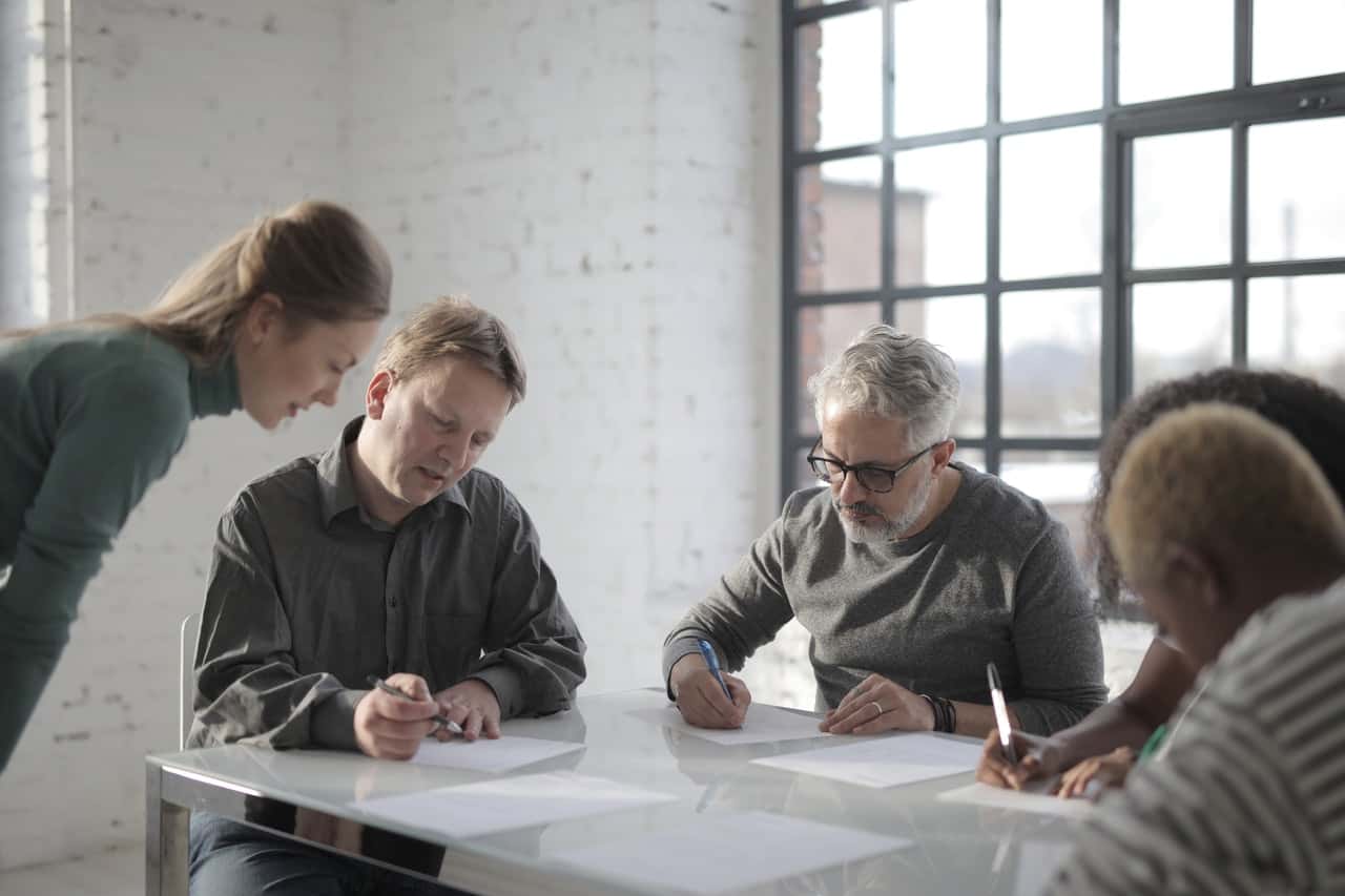 group-of-multiethnic-colleagues-writing-paper-3869374
