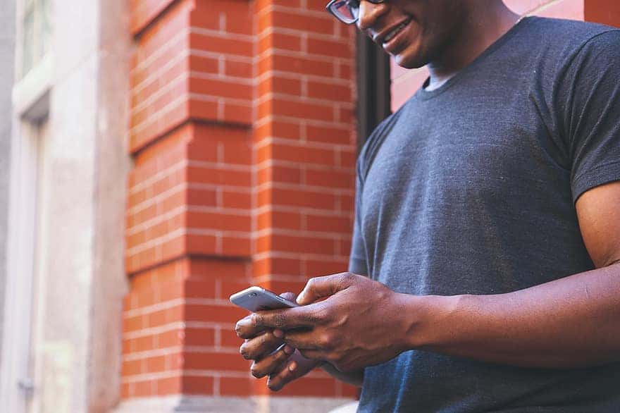 guy-man-texting-smartphone-mobile-technology-hands-bricks-city