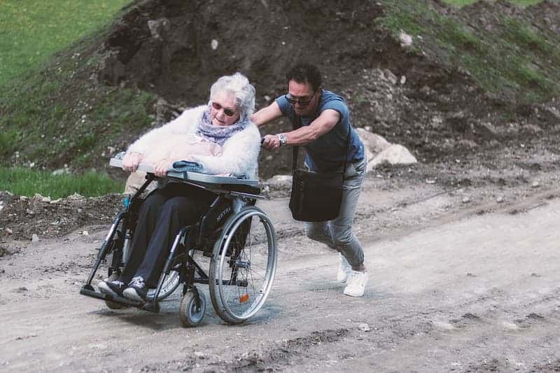 man-pushing-adult-woman-s-wheelchair-during-daytime