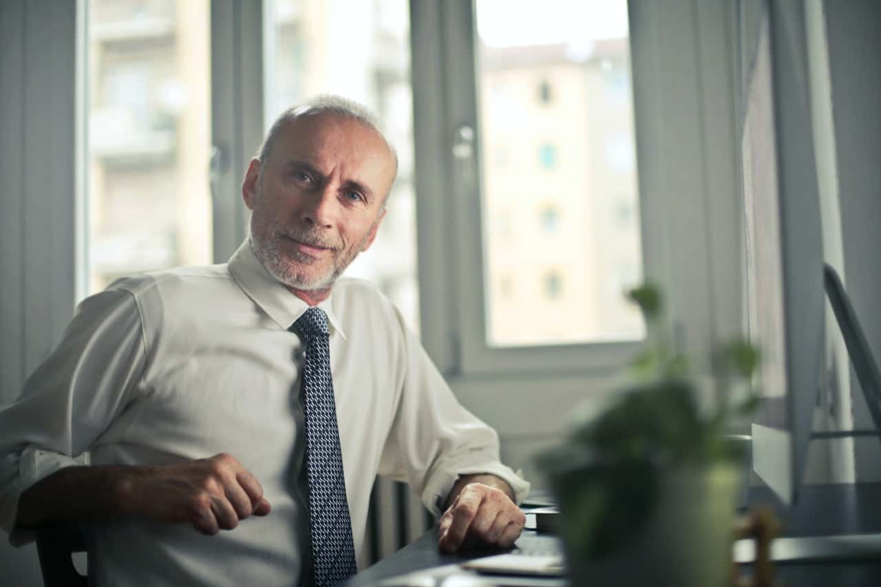 man-sitting-on-chair-beside-table-834863