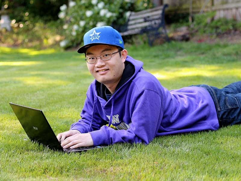 man-using-laptop-computer-on-grass-field