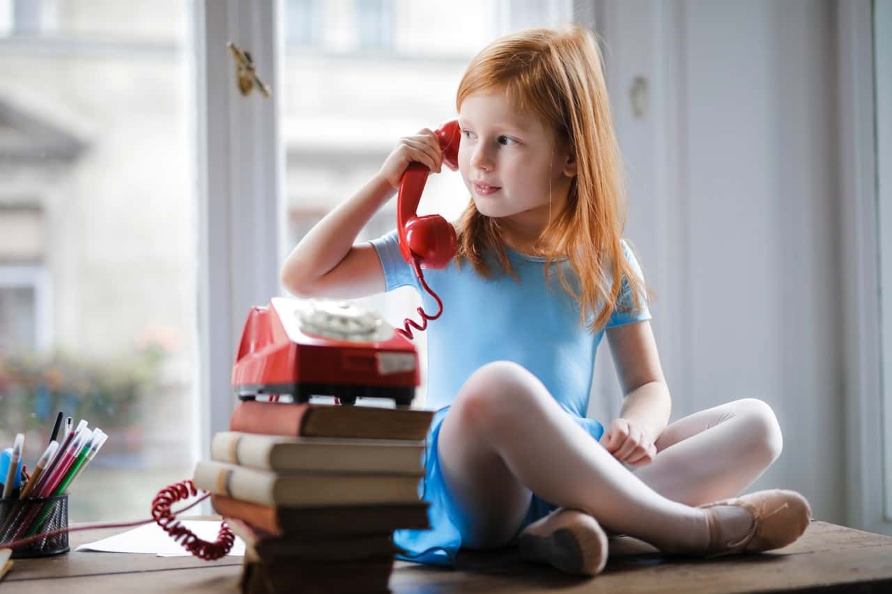 pensive-little-girl-talking-on-vintage-phone-while-sitting-3755618