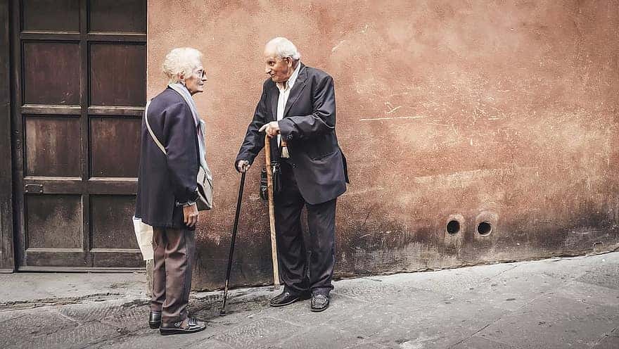 people-old-elderly-man-woman-talking-outside-house