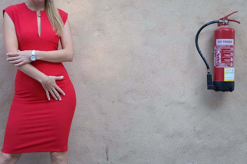 woman-in-red-sleeveless-dress-standing-beside-black-steel-frame