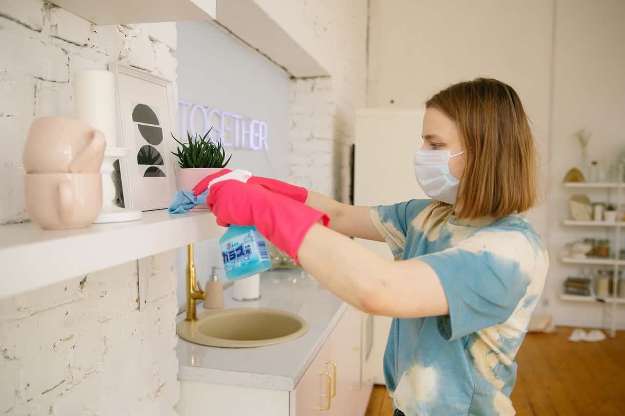 woman-wearing-face-mask-while-cleaning-the-kitchen-4008501