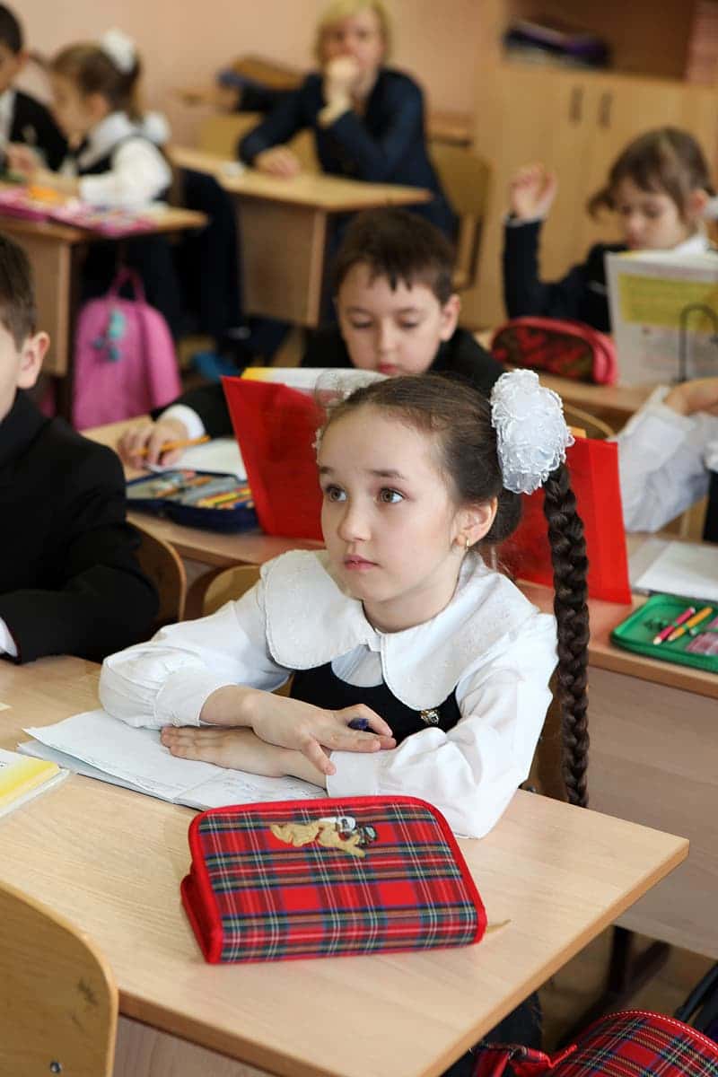girl-in-white-long-sleeve-shirt-sitting-on-chair