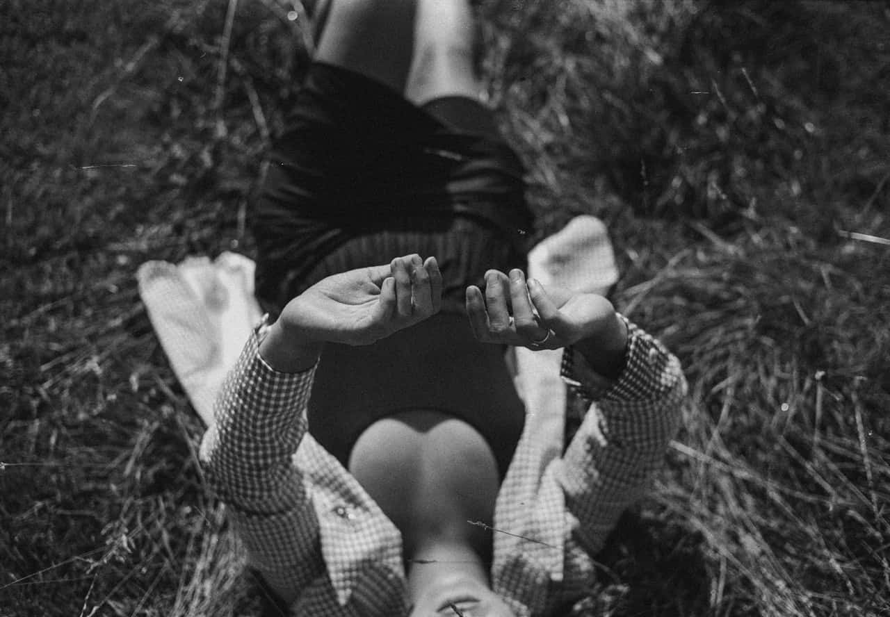 grayscale-photography-of-person-lying-on-grass-3142535