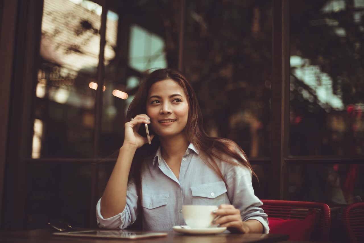 portrait-of-young-woman-using-mobile-phone-in-cafe-323503