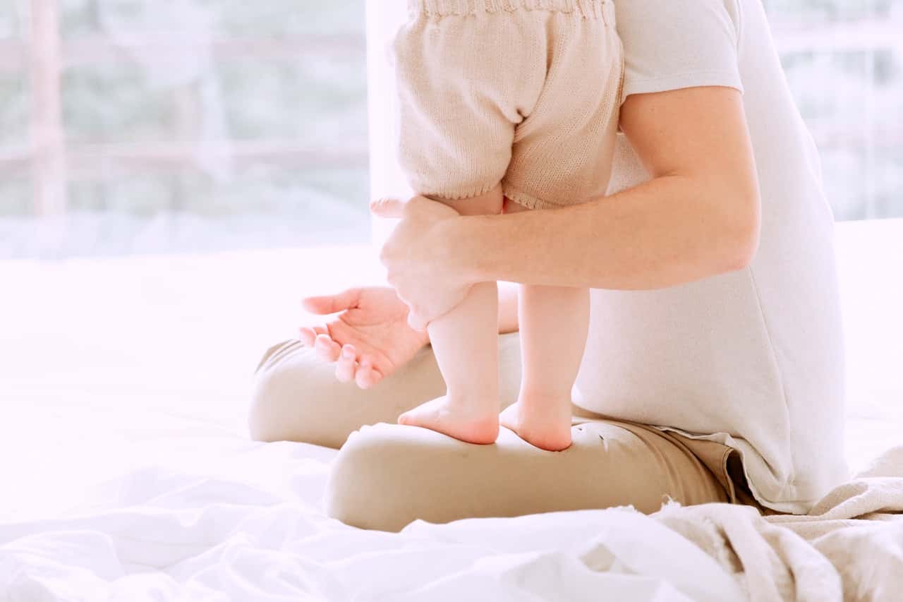 baby-standing-on-her-father-s-lap-3933082