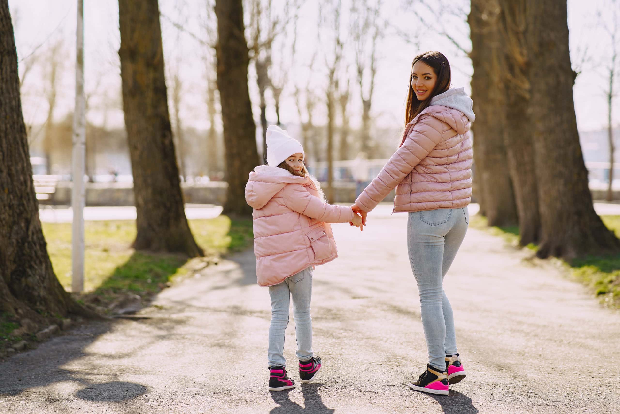 happy-mother-and-daughter-strolling-hand-in-hand-in-city-4127351