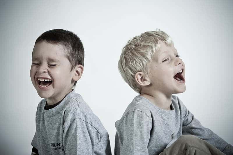 photography-of-two-children-wearing-heather-gray-shirts-while-laughing