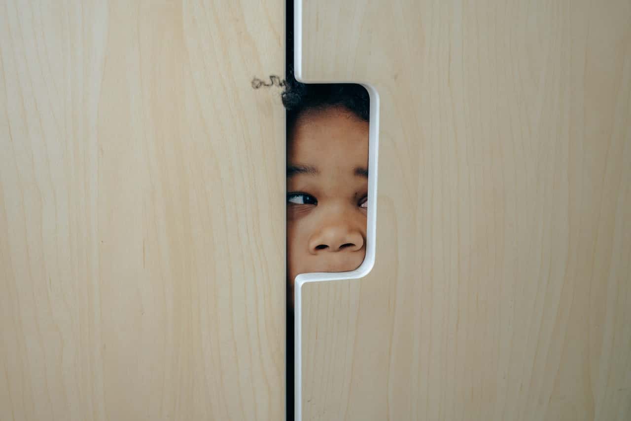 playful-black-little-girl-hiding-in-closet-4545972
