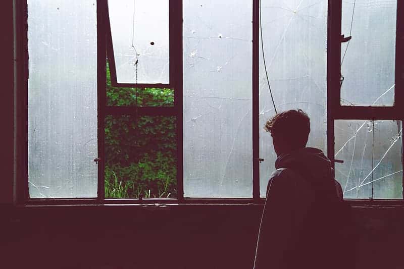 silhouette-photography-of-man-with-jacket-near-window