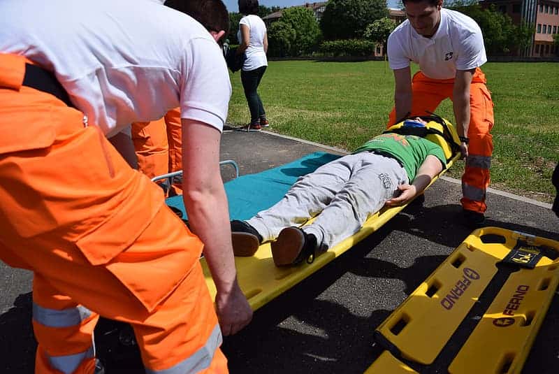 two-men-carrying-person-lying-on-stretcher