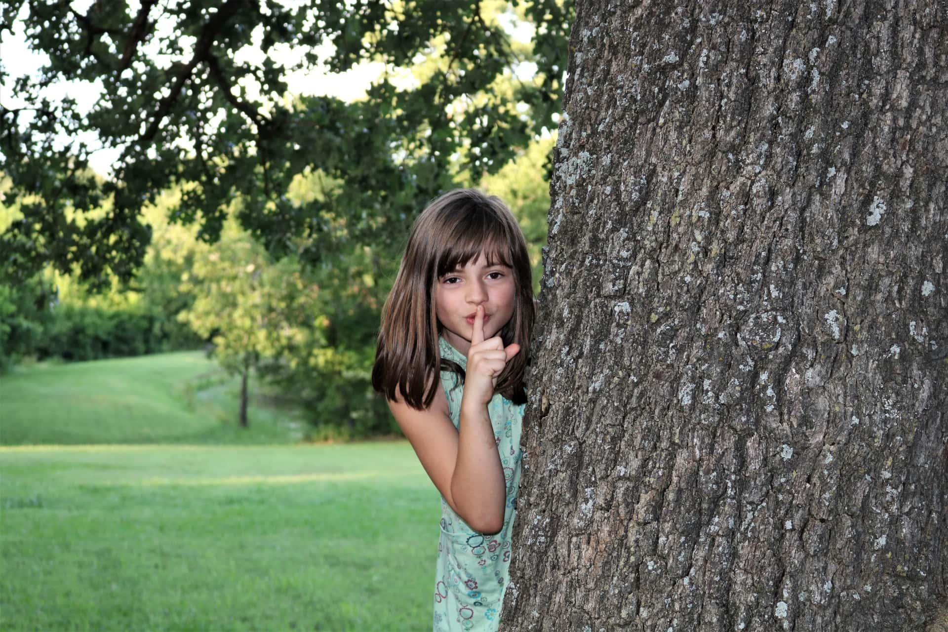 young-girl-hiding-behind-tree