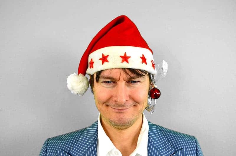 man-in-blue-suit-jacket-with-santa-hat