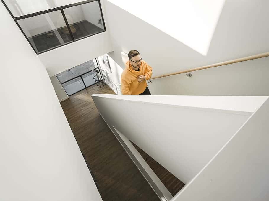 man-wearing-yellow-pullover-hoodie-climbing-on-stairs