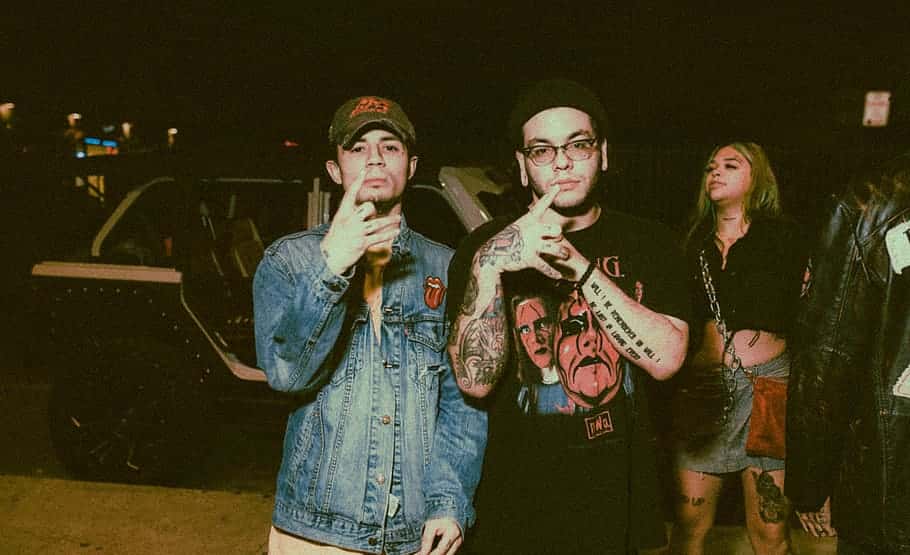 two-men-standing-in-front-of-walking-woman-and-car