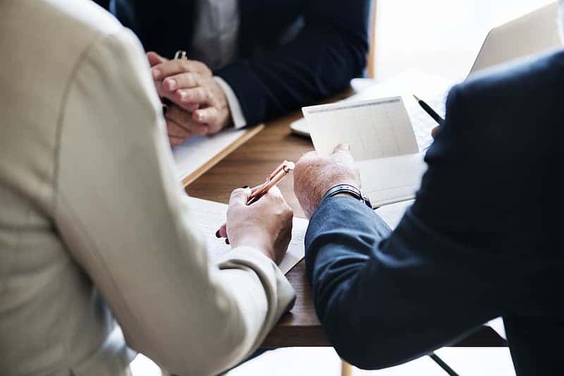 three-person-writing-on-table